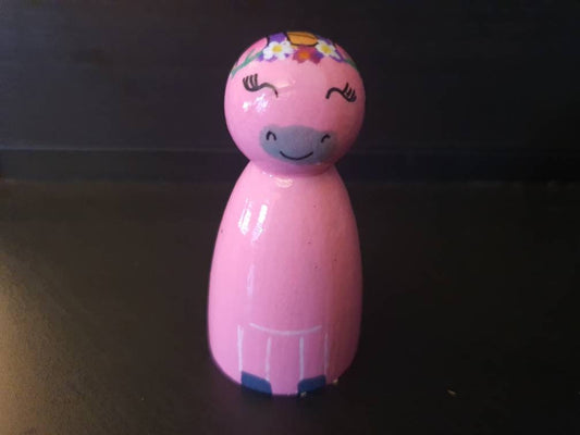 Pink toy figure with a smiling face on a dark background